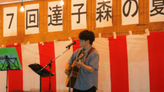 「第17回 達子森の夏祭り」のステージで歌っている音楽クリエイター日景健貴の写真