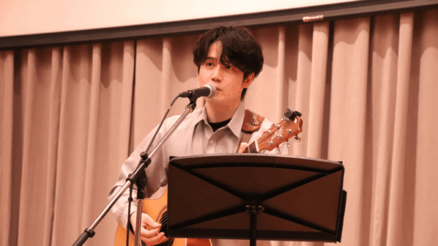 大学祭ライブステージで弾き語りをする日景健貴